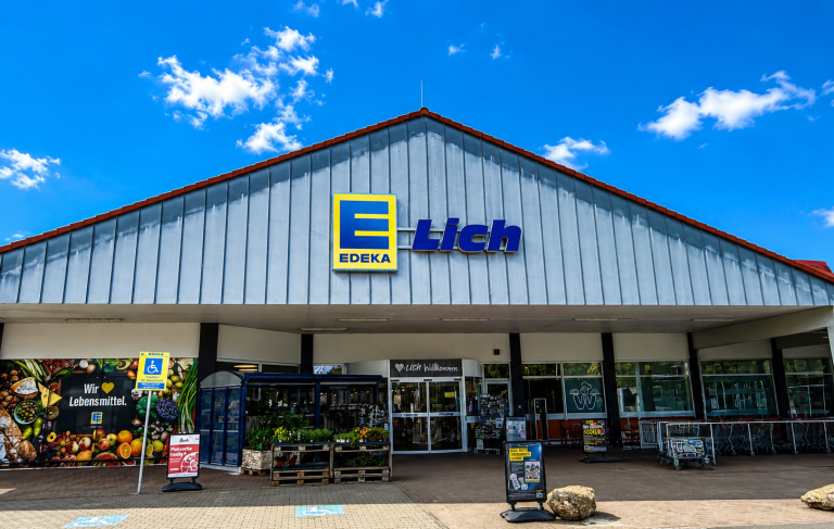Fassade eines Geschäfts mit großem Edeka-Lich-Schild und bunten Wandmalereien.